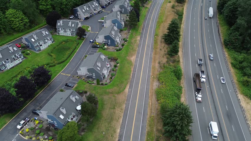 Residential townhome complexes border heavy traffic along Interstate 5. Elevated perspectives reveal architectural density situated near major regional commuting routes found throughout Washington. US
