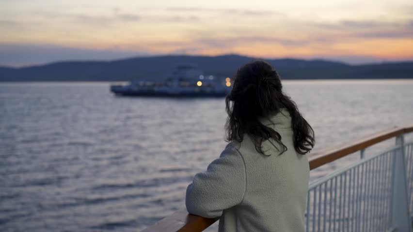 Woman tourist on a ferry boat in 1915 Cannakale bridge in Turkey at sunset
