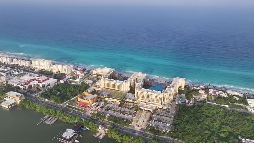Aerial view of a resort complex in Cancun, featuring swimming pools and lush greenery, between the Caribbean Sea and the Nichupte Lagoon in Cancun, Quintana Roo, Mexico.