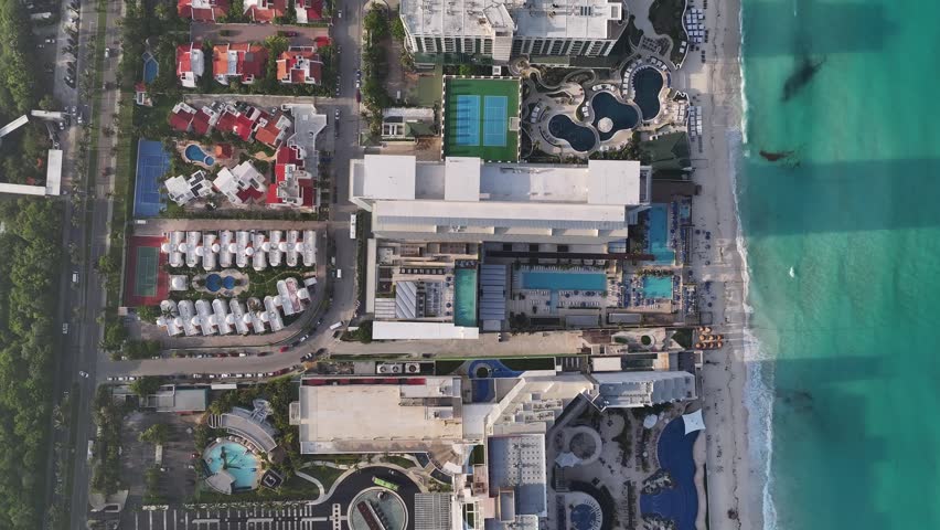 Aerial view of luxury resort hotels with swimming pools and sandy beaches along the coastline in Cancun, Quintana Roo, Mexico.