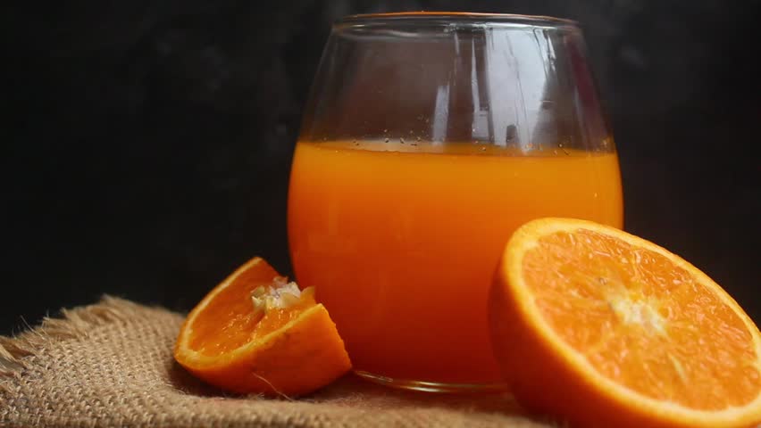 glass of orange juice and orange