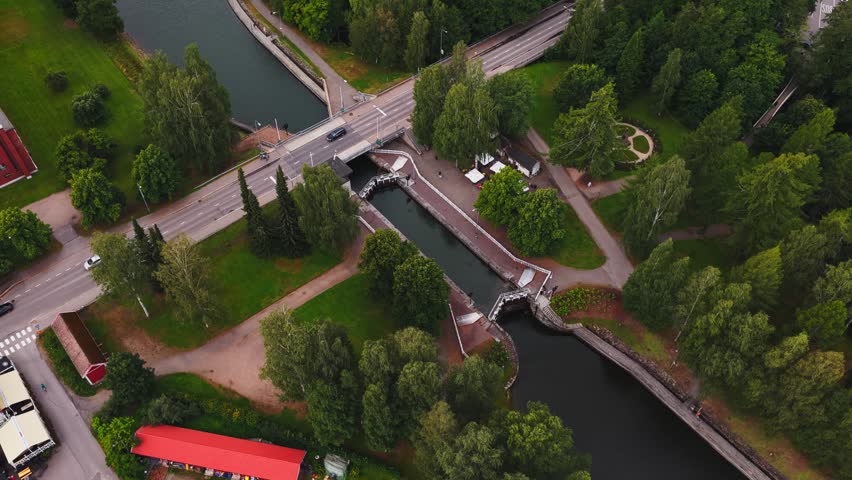 Aerial view of Vaaksy Canal with its historic locks, bridge, and surrounding lush green forest in Vaaksy, Paijat-Hame, Finland.