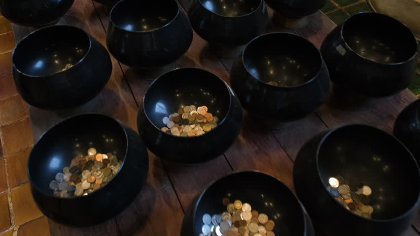 Rows of traditional Buddhist monk alms bowls arranged and displayed inside the temple hall