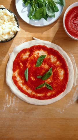 top view, hand preparing pizza, tomato sauce spreading, garnish adding, mozzarella cheese, basil leaves, pepperoni slices, mushroom pieces, olive rings, onion strips, bell pepper chunks, herb sprinkle, sauce ladle, wooden board, rolling pin, stretched dough, circular crust, raw base, ingredient arrangement, even coating, pinch grip, finger placement, palm press, culinary prep, home cooking, fresh produce, colorful topping, kitchen counter, overhead angle, natural light, casual setup, cooking process, handmade meal, Italian dish, baking ready, flour dust, side towel, metal tray, utensil use, clean surface, chef action, family recipe, meal creation, food art, topping layout, savory smell