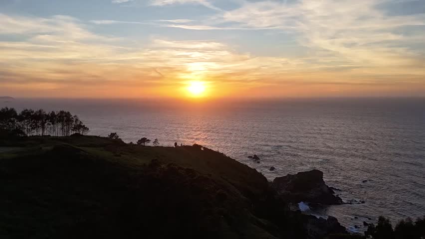 Sunset hyperlapse over the Asturias ocean with cliffs and glowing horizon