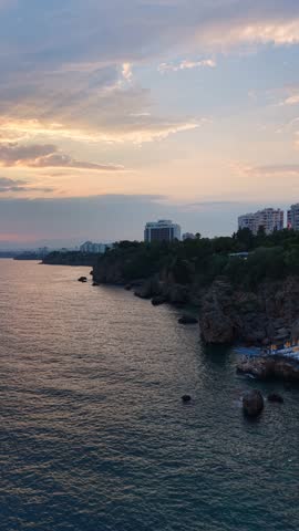 A tranquil sunset view over the ocean with rugged cliffs in the background