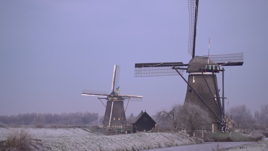 Iconic Dutch Windmills of Kinderdijk in a Frosty Frozen Winter Landscape.
