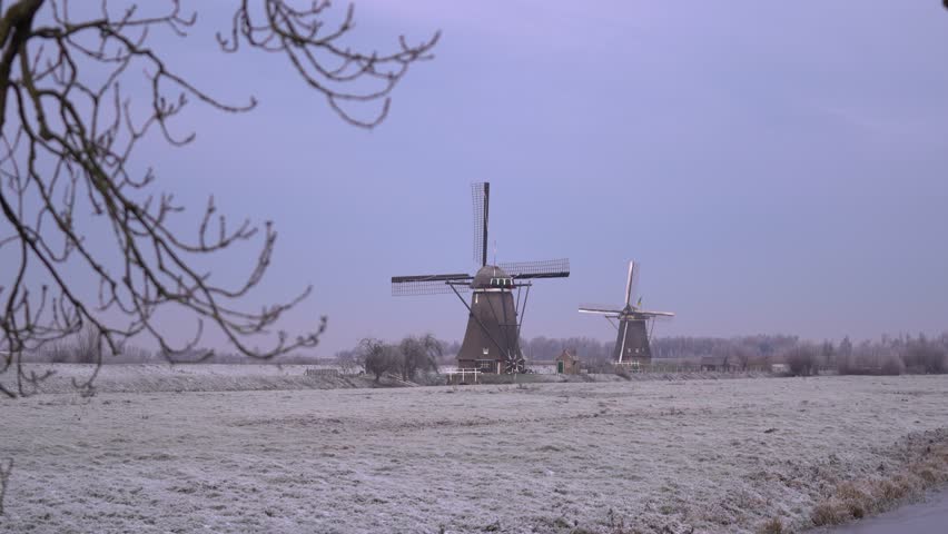 Iconic Dutch Windmills of Kinderdijk in a Frosty Frozen Winter Landscape.