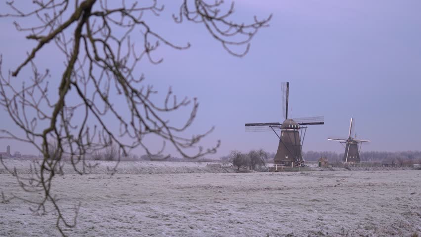 Iconic Dutch Windmills of Kinderdijk in a Frosty Frozen Winter Landscape.