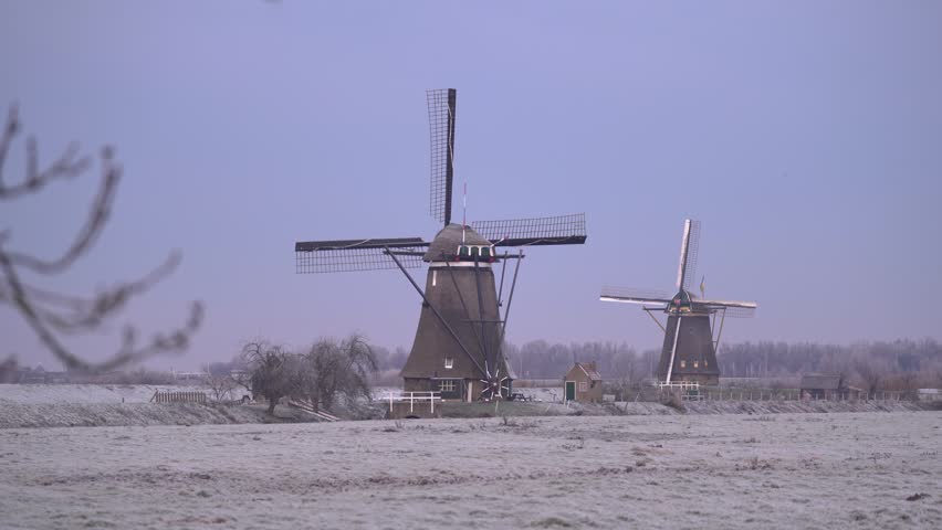 Iconic Dutch Windmills of Kinderdijk in a Frosty Frozen Winter Landscape.