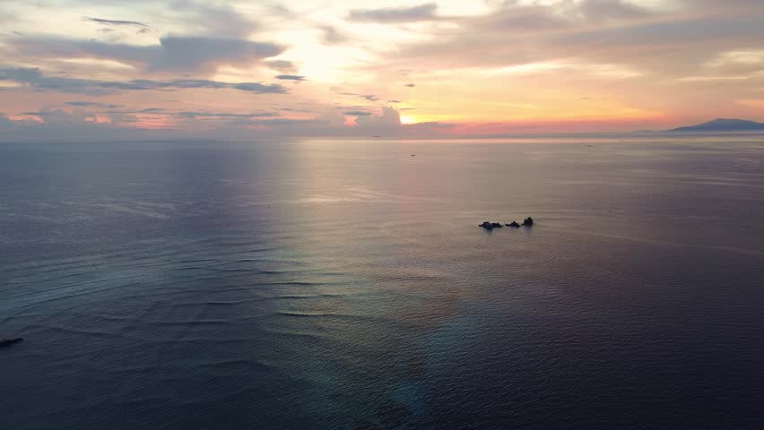 Sunset Over Calm Ocean With Distant Islands