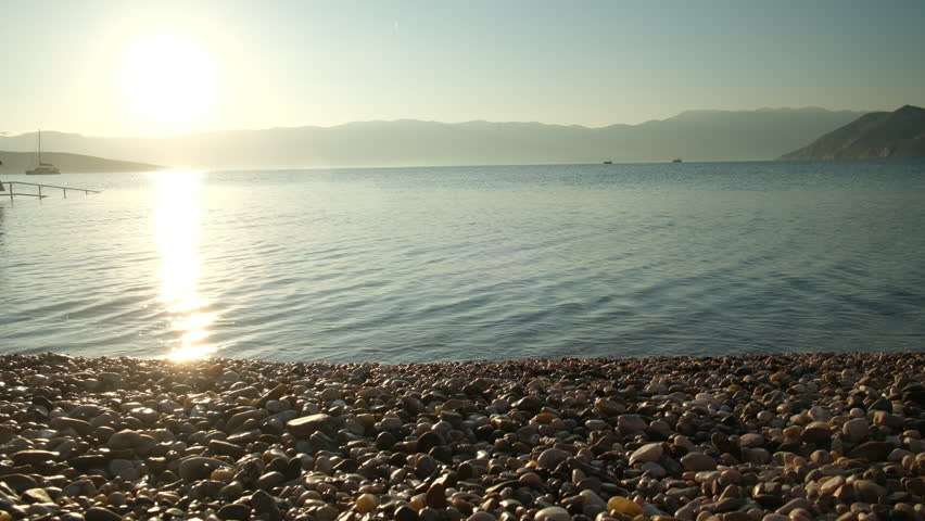 Calm sea sunset with rocky shore and swimmer croatia krk
