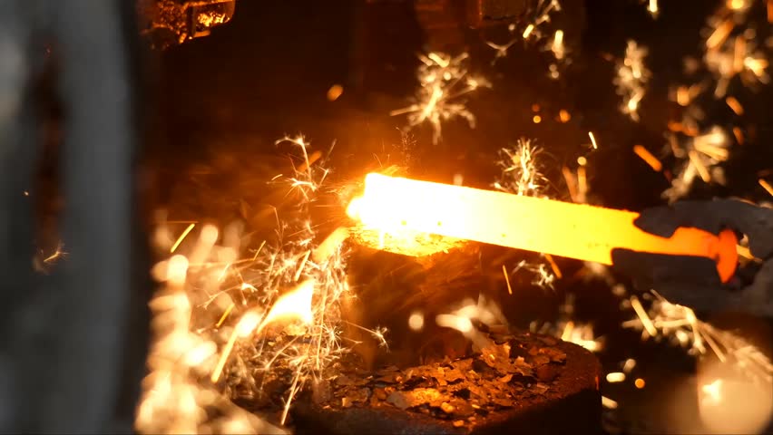 The blacksmith employs a powerful mechanical hammer to shape glowing metal on an anvil, followed by intense reheating within a coal fire furnace for further industrial forging operations.