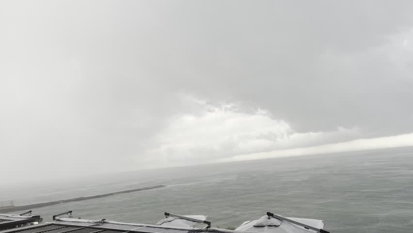 Dramatic storm clouds gathering over the sea at a coastal restaurant