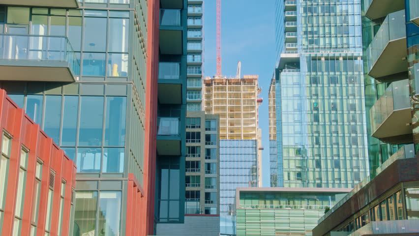 Cinematic 4K footage of modern residential and commercial high-rise buildings in downtown Toronto, Ontario, Canada. Features contemporary architecture, glass facades, urban development, luxury condominiums, construction, and city skyline details suitable for business, real estate, architecture, finance, corporate, and travel productions.