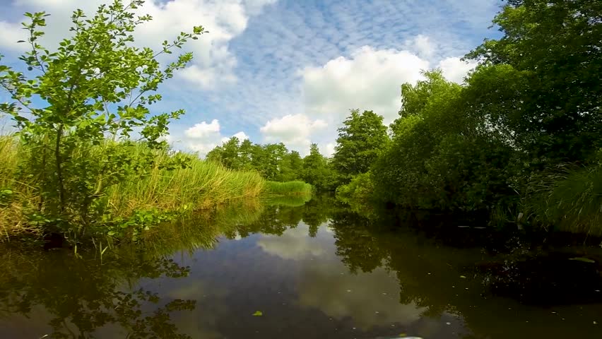 Point of view of a boat boat cruising through Dutch channels, Netherlands