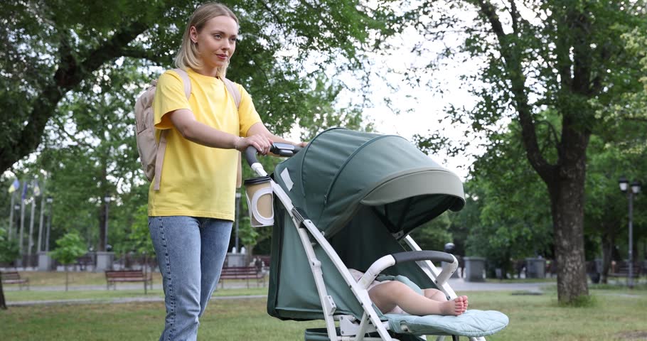 Baby carriage. Mother walking with her child in stroller outdoors