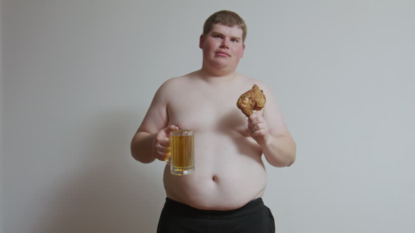 Overweight Man Holding Fried Chicken and Beer Mug. Overweight man eat a fried chicken leg and a mug of beer. Obesity, unhealthy eating, alcohol, excess calories, and poor lifestyle concept.