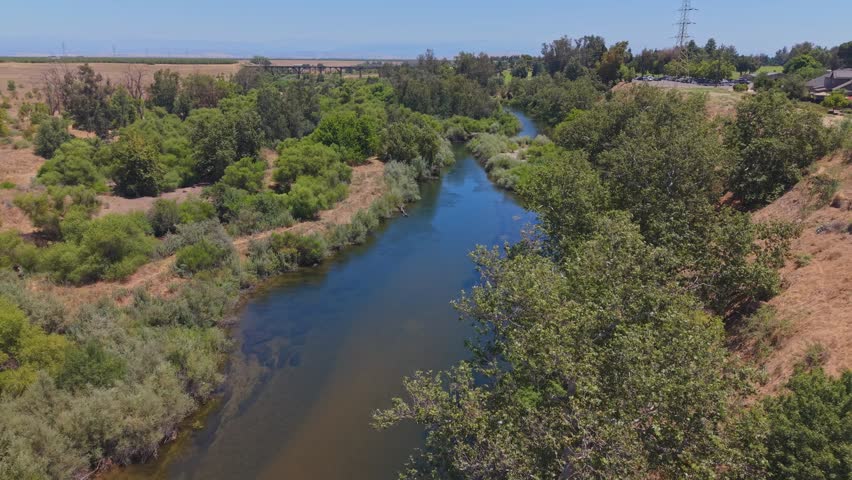Panning aerial drone footage moving right to left over the San Joaquin River in California