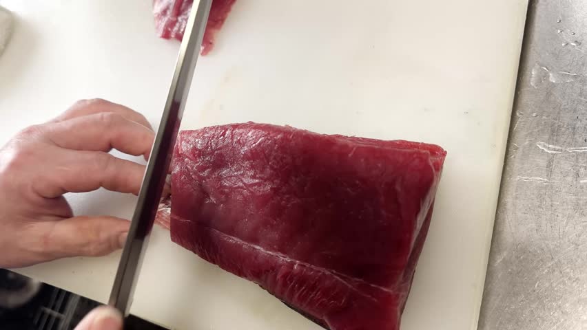 Fresh Japanese raw tuna, a chef slicing thin pieces of red lean meat with a knife, traditional Japanese cuisine, Japan