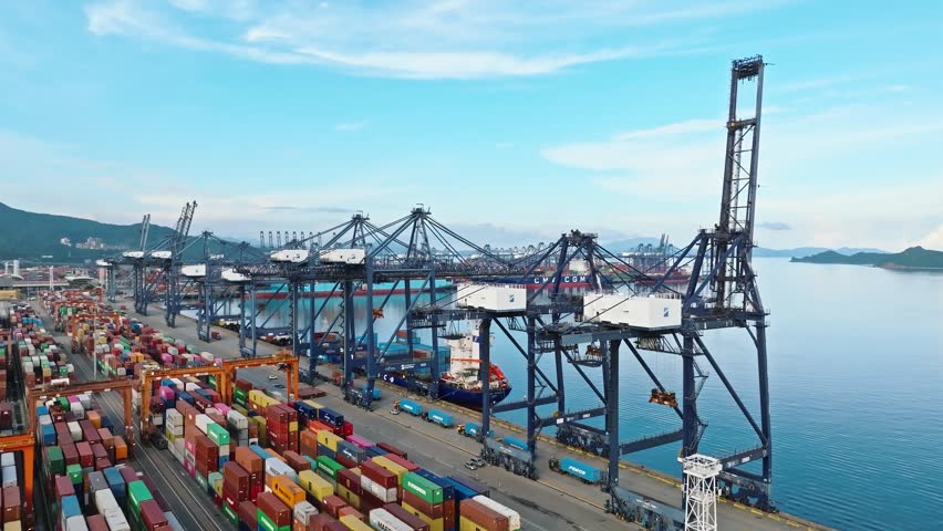 4K aerial view of massive container ship and gantry cranes at Shenzhen Port, global maritime trade hub in China.