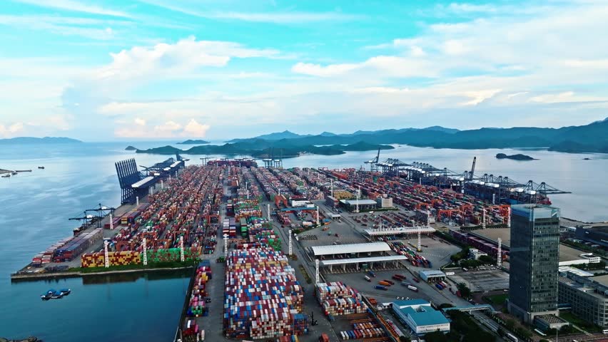 4K aerial view of massive container ship and gantry cranes at Shenzhen Port, global maritime trade hub in China.