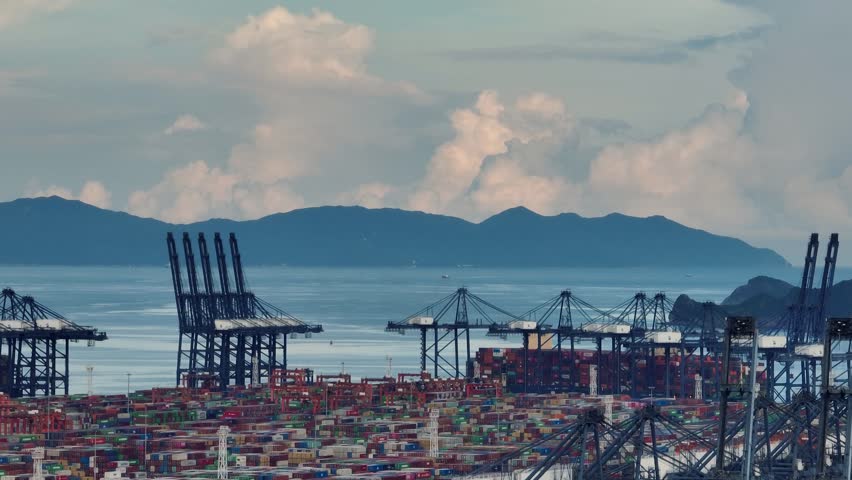 4K aerial view of massive container ship and gantry cranes at Shenzhen Port, global maritime trade hub in China.