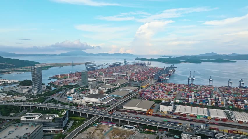 4K aerial view of massive container ship and gantry cranes at Shenzhen Port, global maritime trade hub in China.