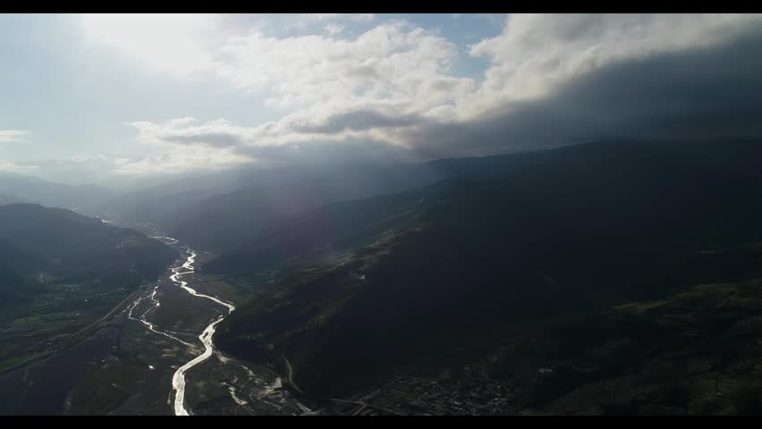 Aerial view of a scenic mountain valley at sunset.
