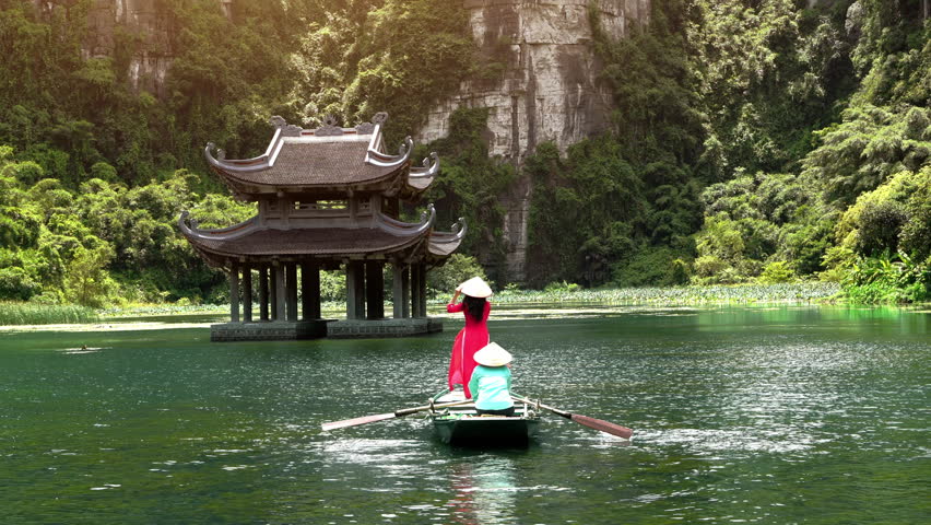 Tourists take a boat trip on the river at Trang An, Ninh Binh Province, Vietnam.