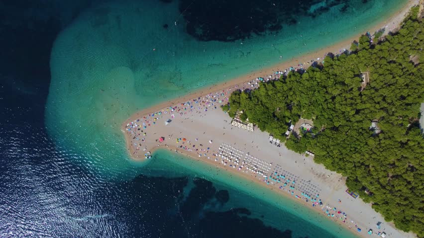Incredible aerial view of the famous zlatni rat beach on the island of brac, croatia, with tourists swimming in the clear blue sea