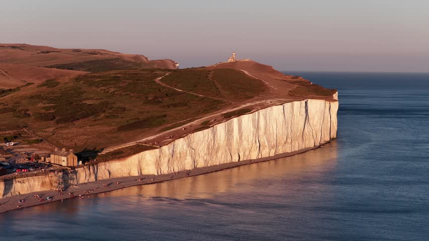 Seven Sisters Cliffs in England during sunset with calm ocean waters below