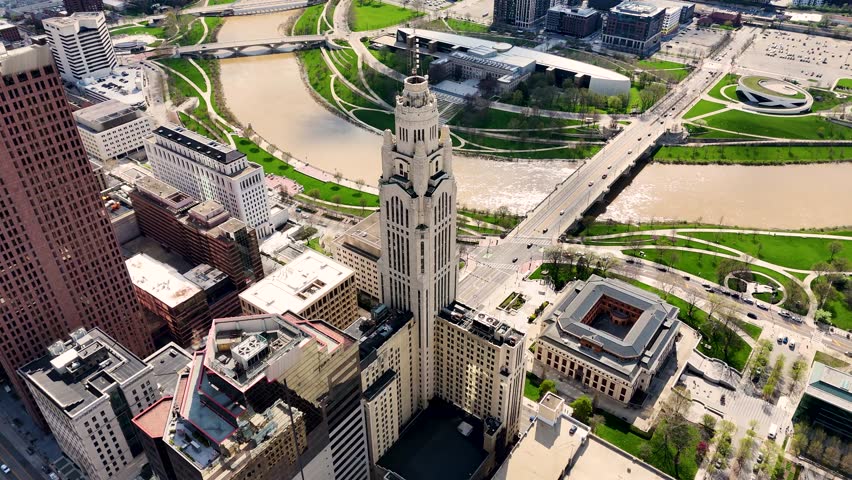 A cinematic drone shot capturing the modern skyline of Columbus, Ohio, USA, showcasing downtown architecture, urban development, office buildings, streets, and the vibrant atmosphere of the state capital on a clear day