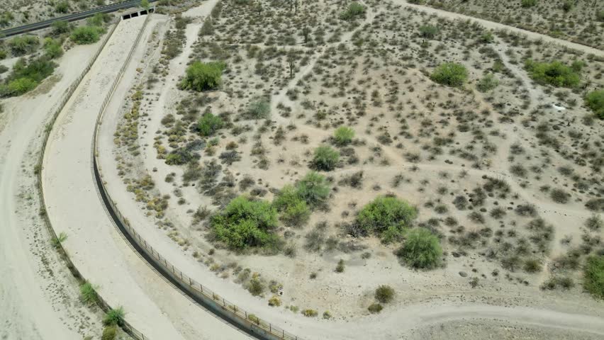 An aerial footage of a bridge over dry wash in the landscape of Mesa, Arizona, USA on a clear sunny day