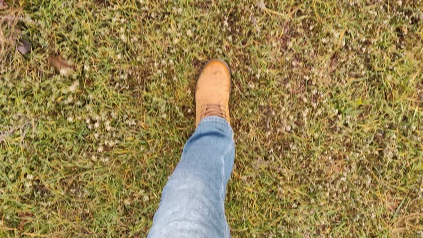 View of legs in brown boots while walking in the park