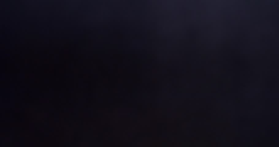 Ridged potato chips falling in slow motion on black background