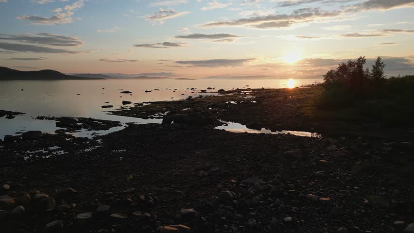 A drone shot of a sunset over a rocky coastline on the Stora Lulevatten in Norrbotten County, Sweden