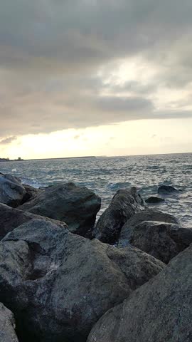 the waves crashing against the rocks and shore