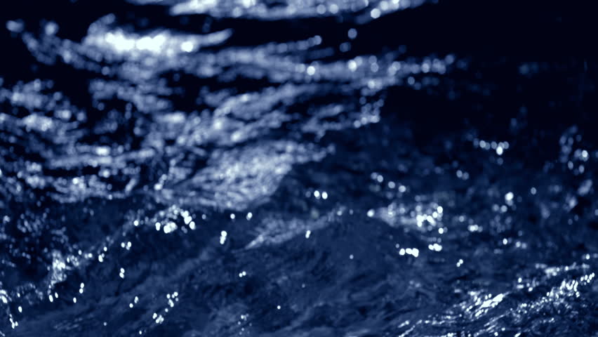 Fresh blue water macro background loop with splashing liquid on dark black backdrop. 3D animation wave fluid swirling backplate with copy space. Clean abstract bubbles texture.