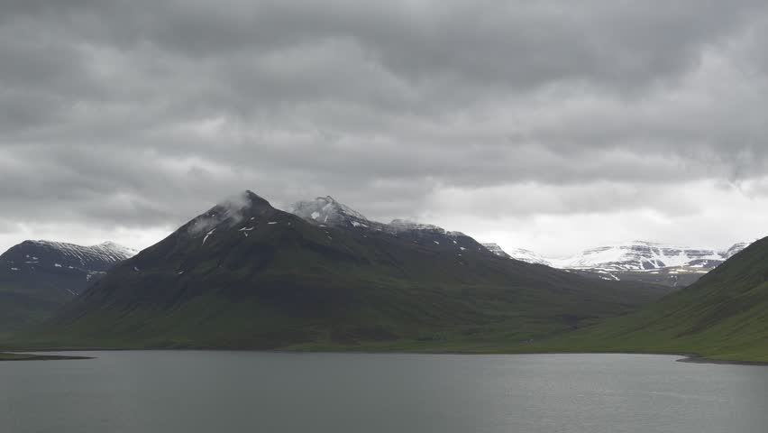 Wide Shot of Majestic Snow-Capped Mountains and a Calm Lake in Iceland