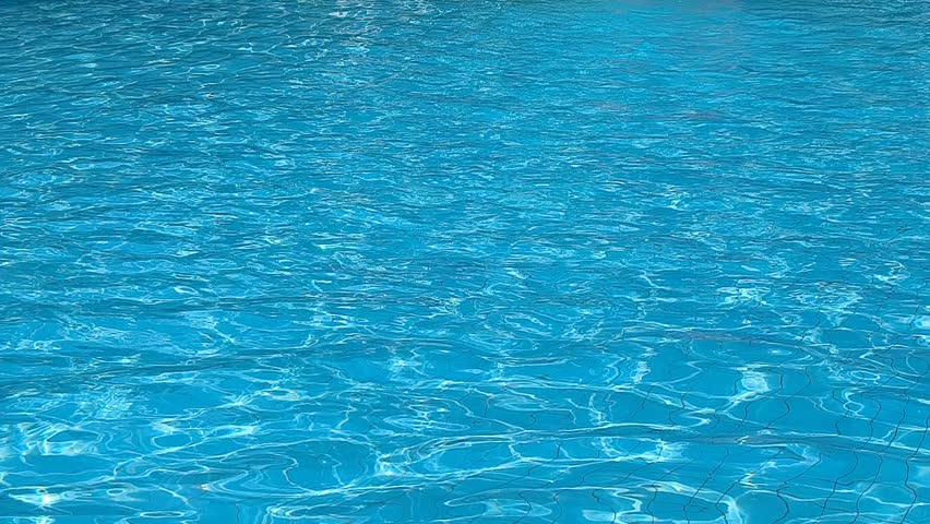 Loopable background of blue water ripples in a swimming pool with bright sun reflections, abstract texture of turquoise water surface moving under sunny day.