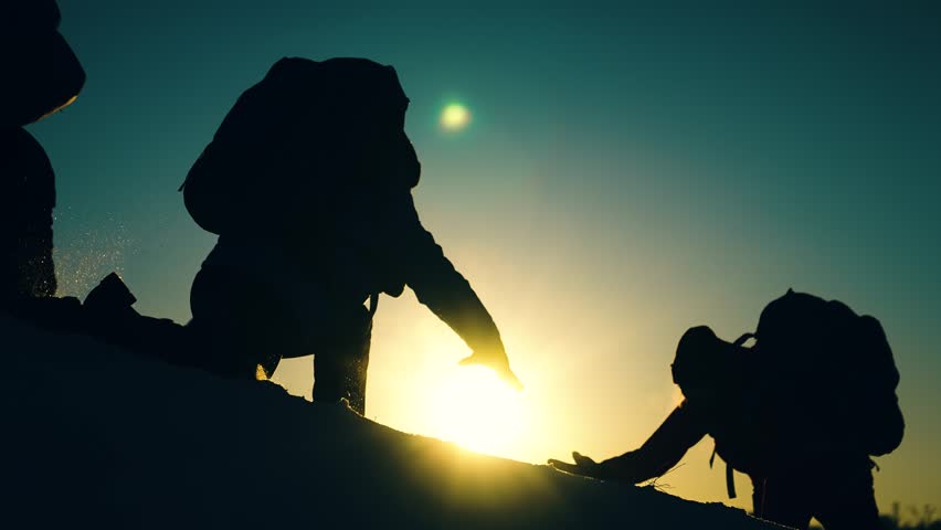 Business teamwork. Achieve your goal. Climbers holding hands, climb to top mountain. Silhouettes. Victory business team. Free people strive victory. Teamwork travel. Tourists conquer mountain together