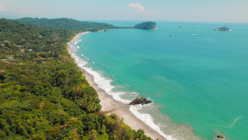 Playa Espadilla long sandy beach located in Manuel Antonio Costa Rica with lush tropical forest and turquoise ocean