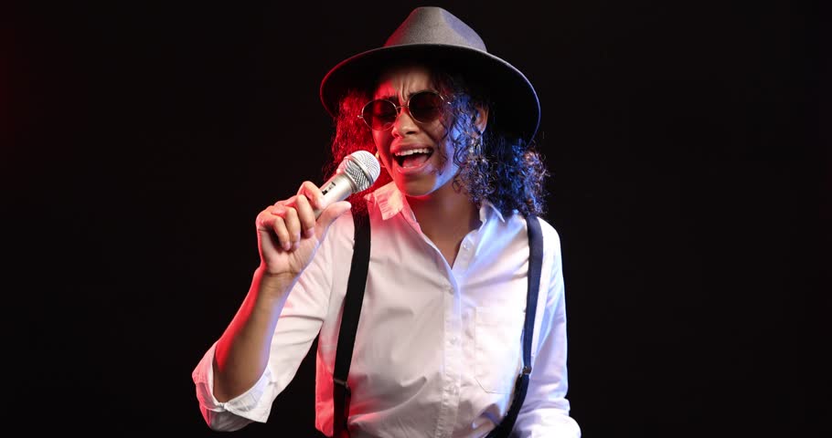Professional singer performing on dark background with color lights