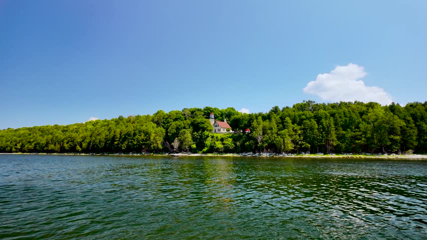 View from the waters of Green Bay looking back toward the historic Eagle Bluff Light Station overlooking Peninsula State Park in Door County, Wisconsin.