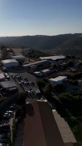 Vertical Aerial Drone Flight Over Kibbutz Tzuba in the Jerusalem Mountains, Revealing Greenhouses, Agricultural Buildings, Surrounding Forests and Scenic Judean Hills Landscape in Israel