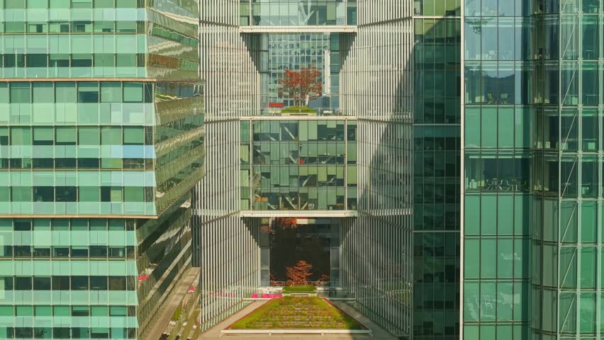 Aerial view dolly in establishing of a modern building with gaps in its structure in Nueva Las Condes on a sunny day, Santiago, Chile