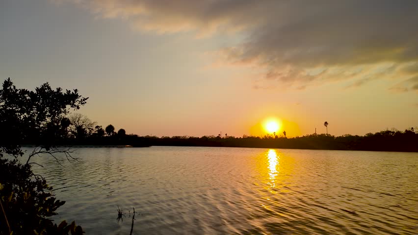 A peaceful sunset settles over an inlet at Fort De Soto Campground in Tierra Verde, Florida as gentle winds send ripples across the glowing water.