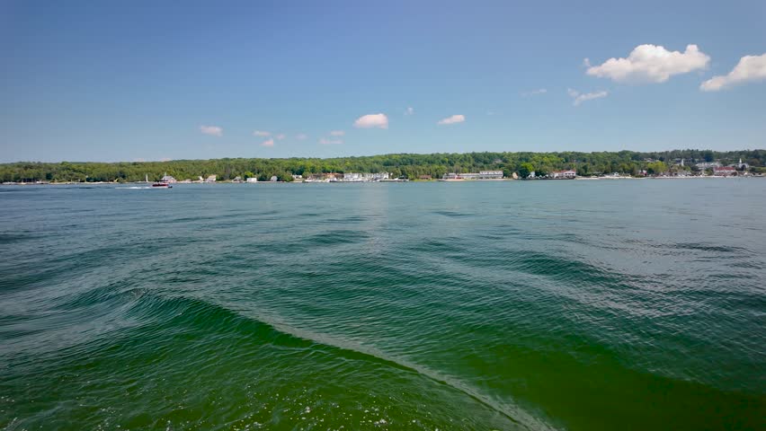 View from a boat on the calm waters of Green Bay looking back toward the village of Ephraim, Wisconsin, on a beautiful summer day in Door County.
