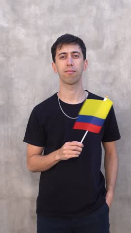 Male adult waving Colombia country flag. Vertical slowmo.